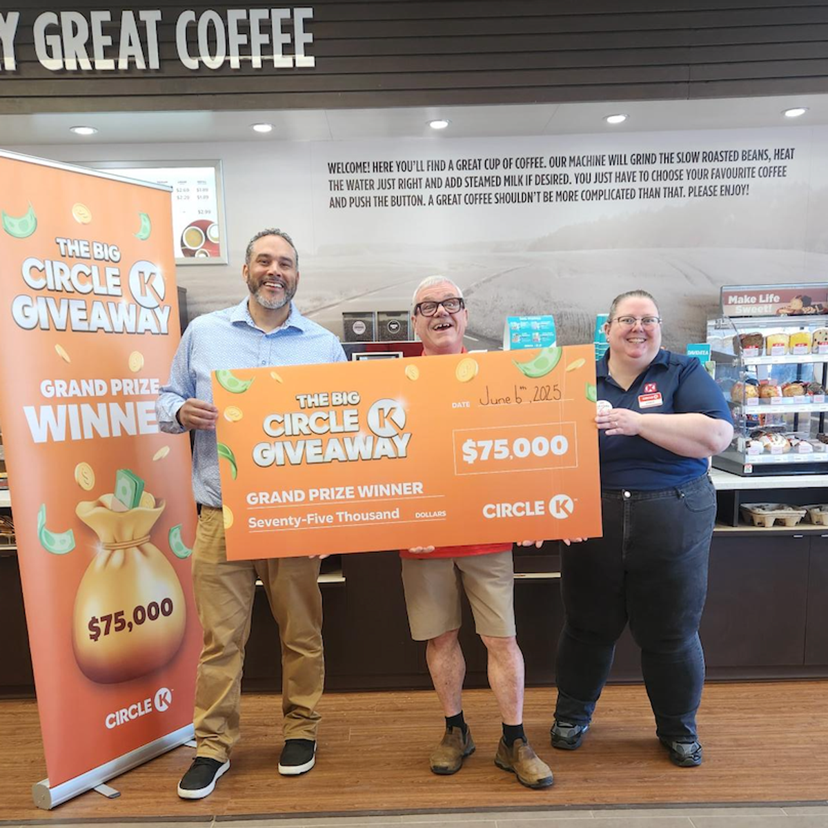 Three people smiling and holding a $75,000 grand prize cheque from Circle K Giveaway at a Circle K coffee station in New Brunswick.