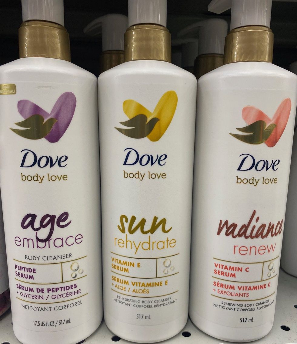 Three white bottles of body wash on a store shelf.