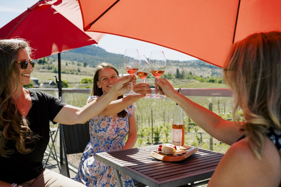 Three women each raising their wine glass at Tightrope Winery.