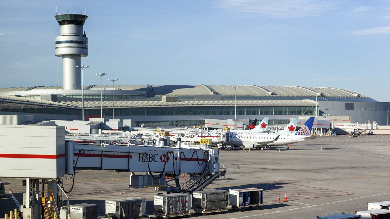 toronto international airport tarmac with planes and air traffic controller tower in the background