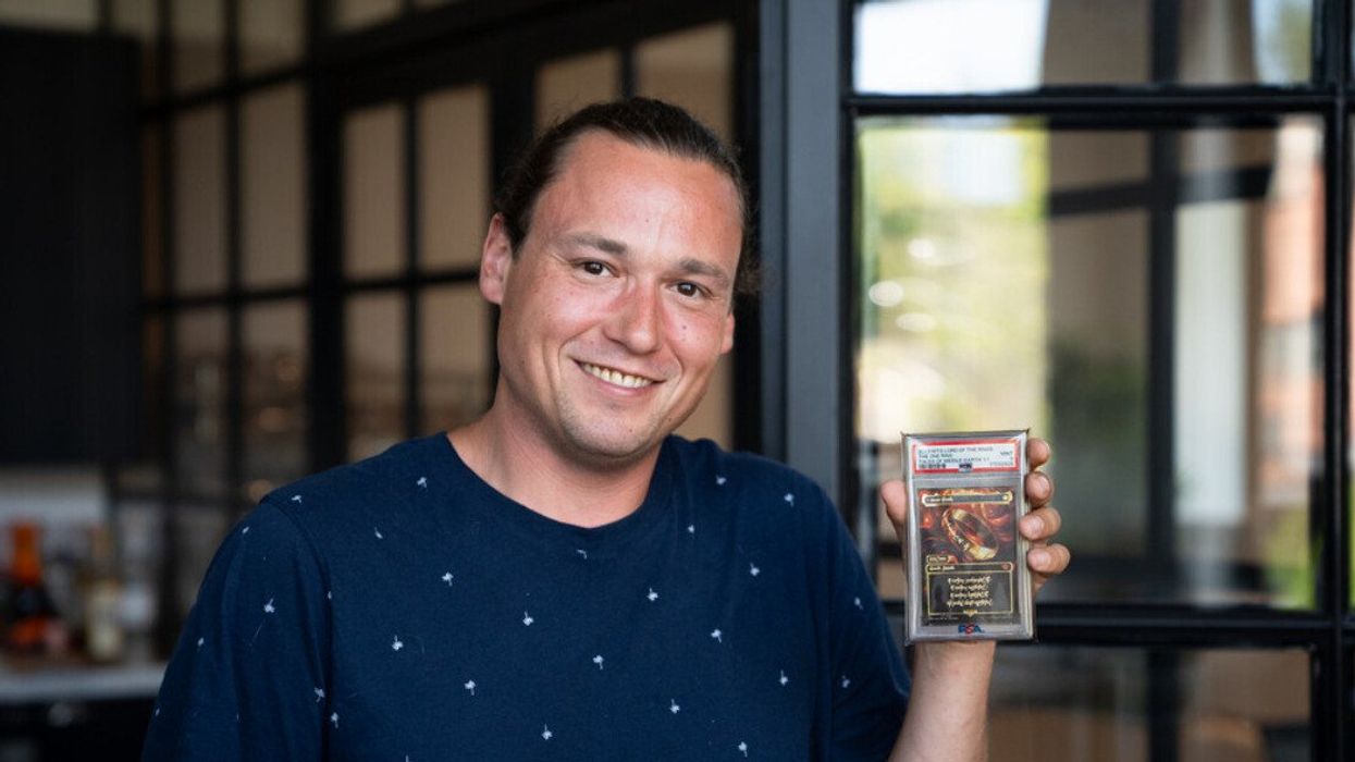 Toronto man Brook Trafton holding the ultra-rare 'One Ring' Magic: The Gathering Card.