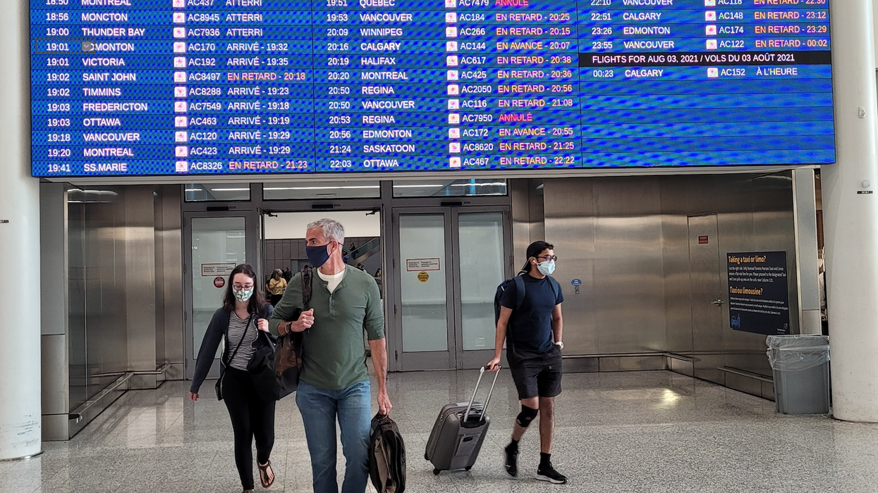 Toronto Pearson Airport passengers wearing protective face masks inside.