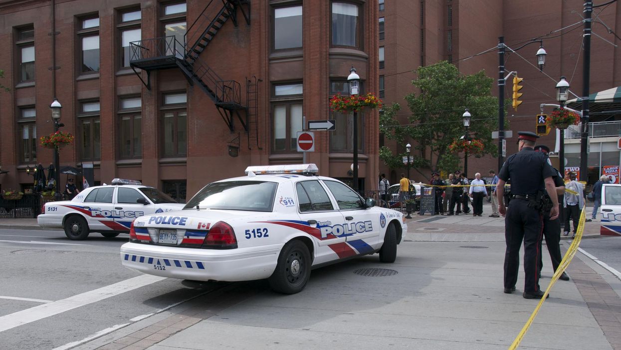 Toronto Police are on the scene, surrounded by police officers and bystanders.