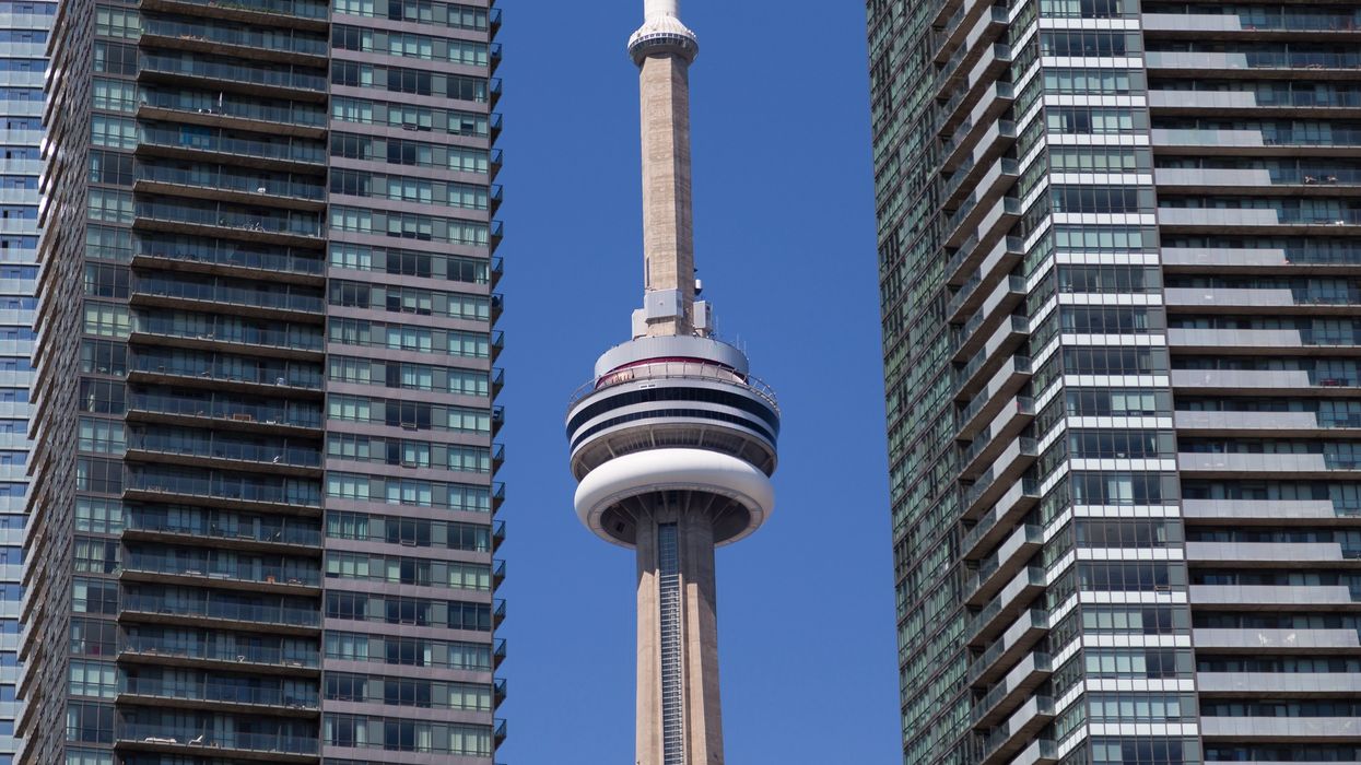 Toronto's CN Tower between two condo buildings.