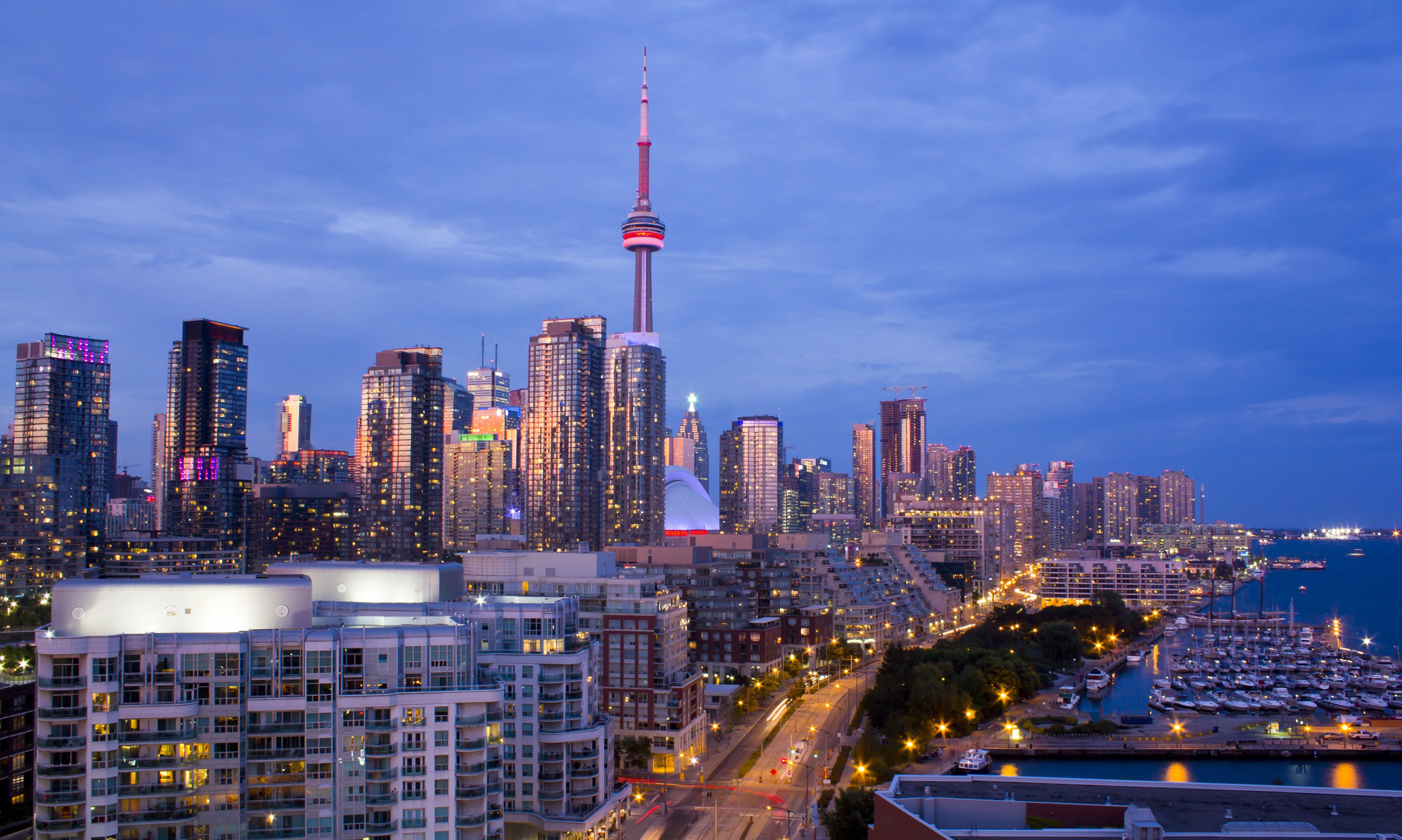 Toronto skyline at night with the CN Tower and other skyscrapers lit up.