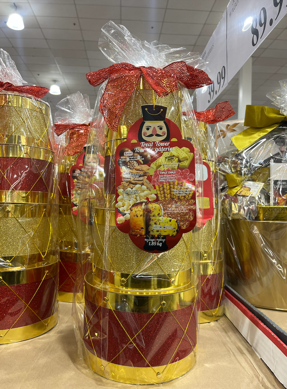 Tour de bo\u00eetes d\u00e9cor\u00e9es en tambours empil\u00e9es remplies de surprises sucr\u00e9es : chocolats, biscuits roul\u00e9s Pirouline, popcorn, et plus.