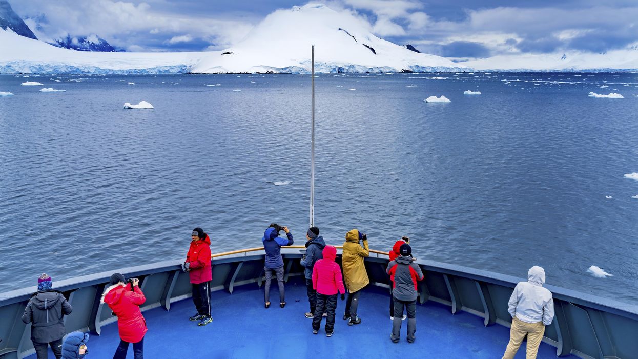 Tourists taking photos on a boat in Antarctica.