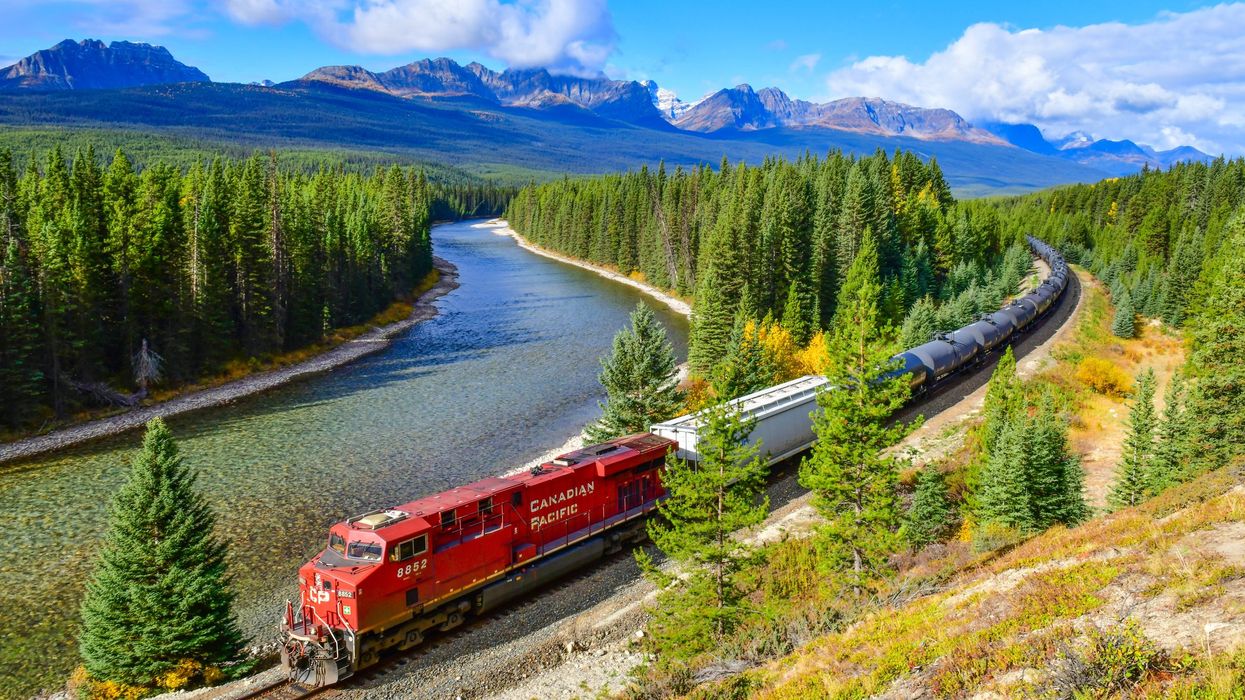 Train driving past mountains.