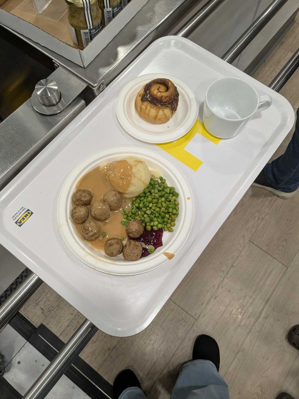 Tray with a plate of meatballs, cinnamon bun, and coffee mug from IKEA