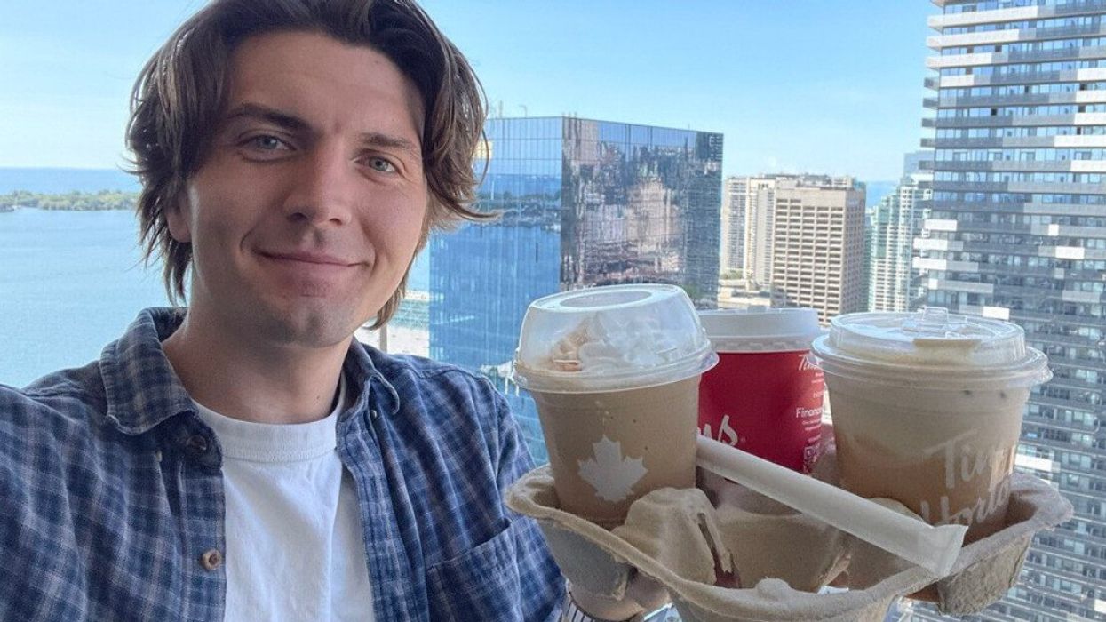 Tristan Wheeler holding a bunch of Tim Hortons fall drinks.