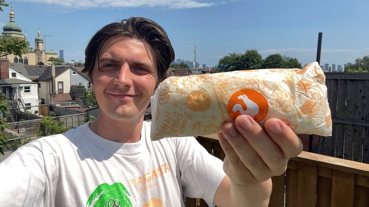 Tristan Wheeler holding the Crispy Chicken Wrap from Popeyes.