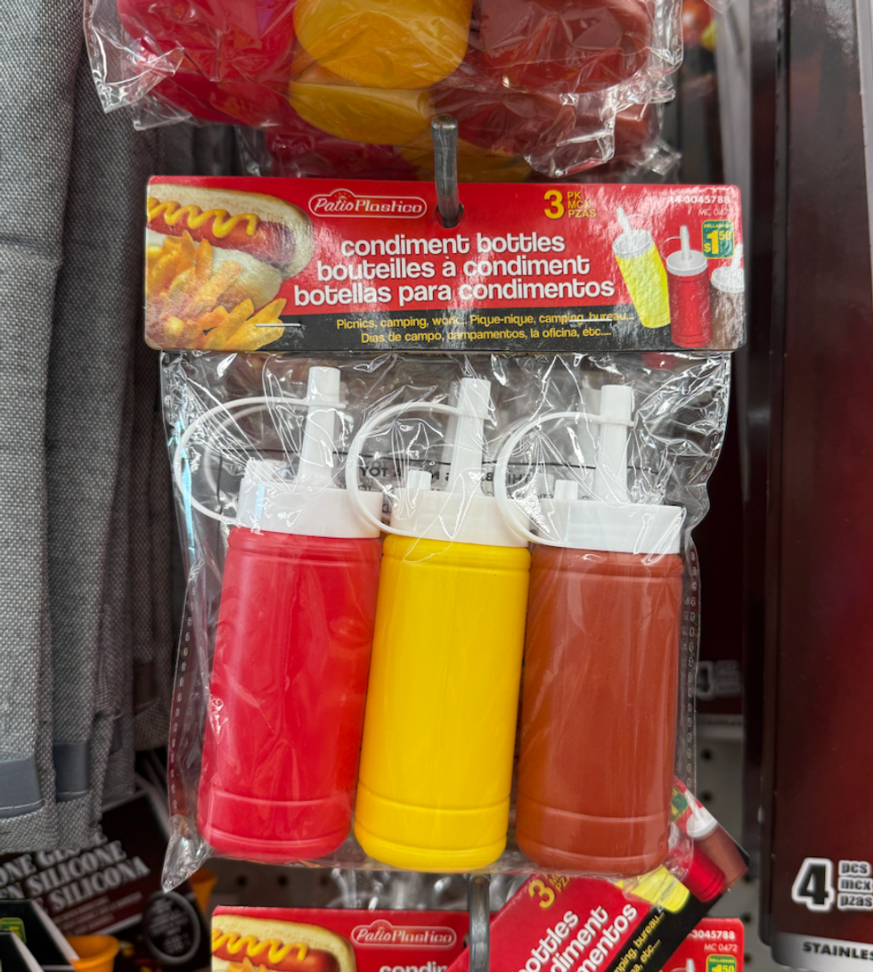 Trois bouteilles \u00e0 condiments rouge, jaune et brune, emball\u00e9es sous plastique.