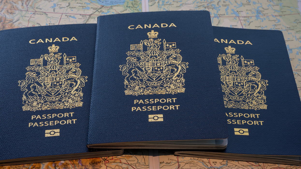 Trois passeports canadiens étalés sur une map du monde.