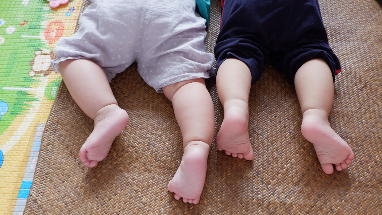 Two babies lay on their stomachs.