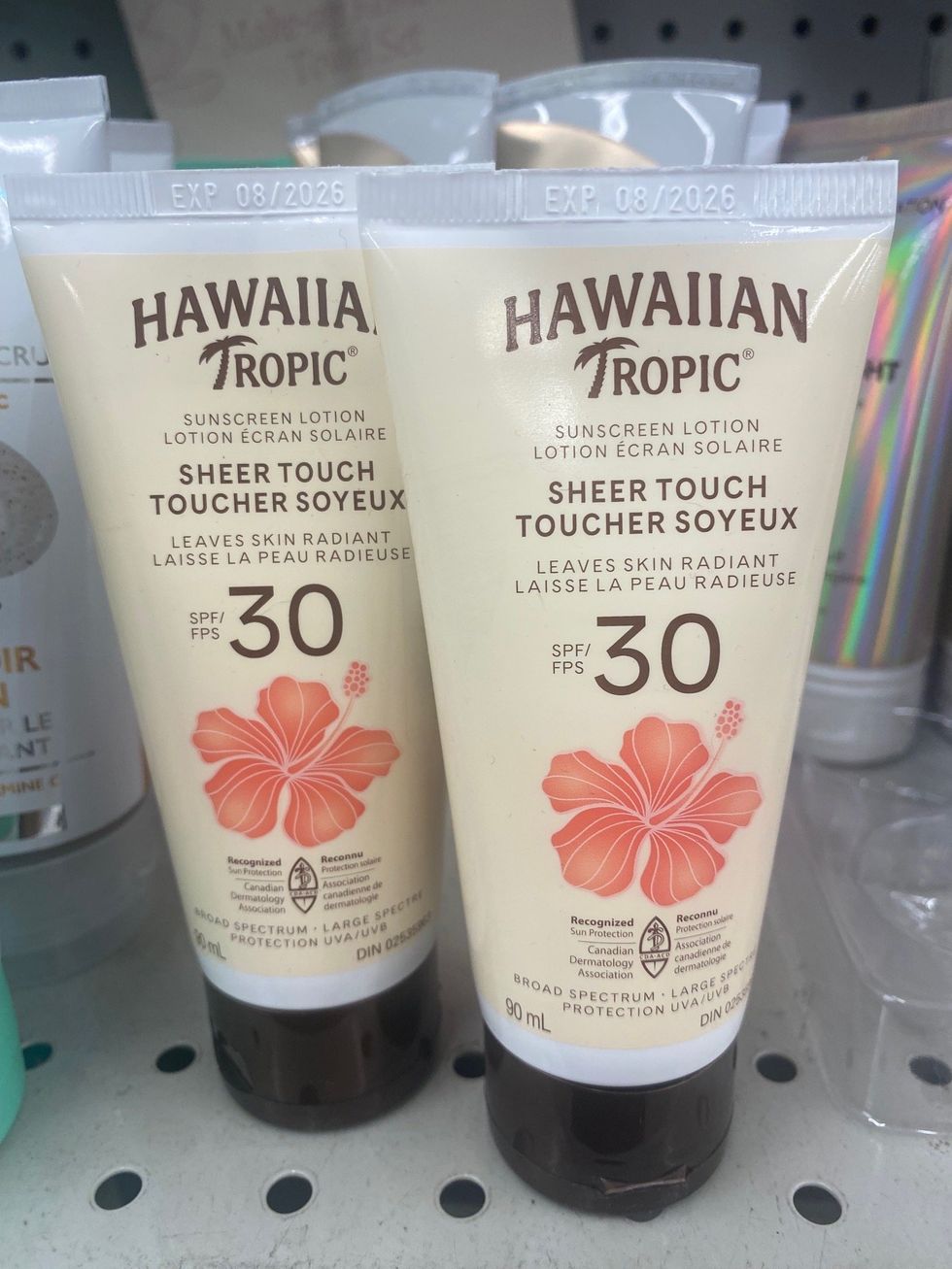 Two beige bottles of sunscreen on sale at a store.