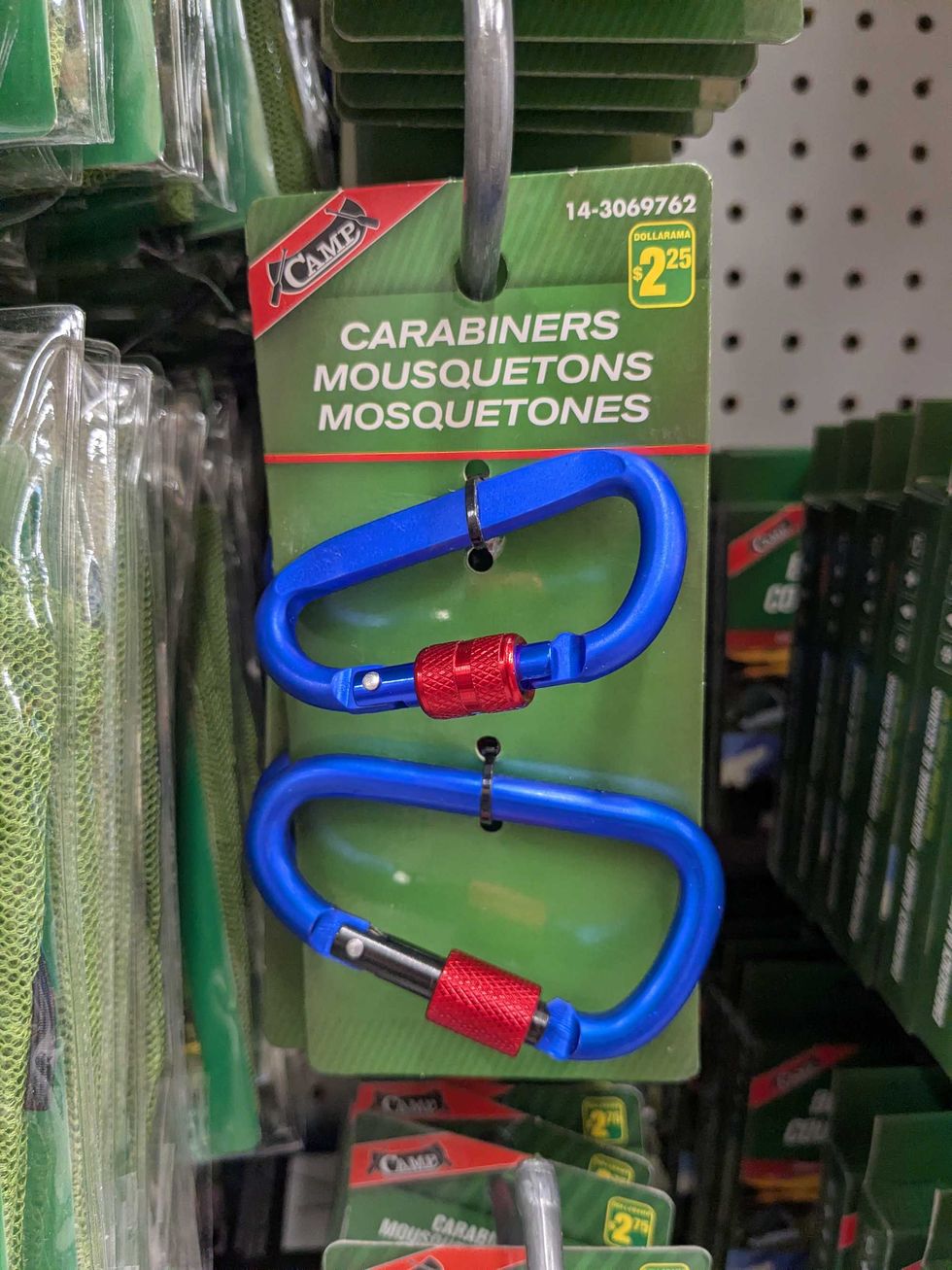 Two blue carabeners in a package hanging on a shelf at Dollarama