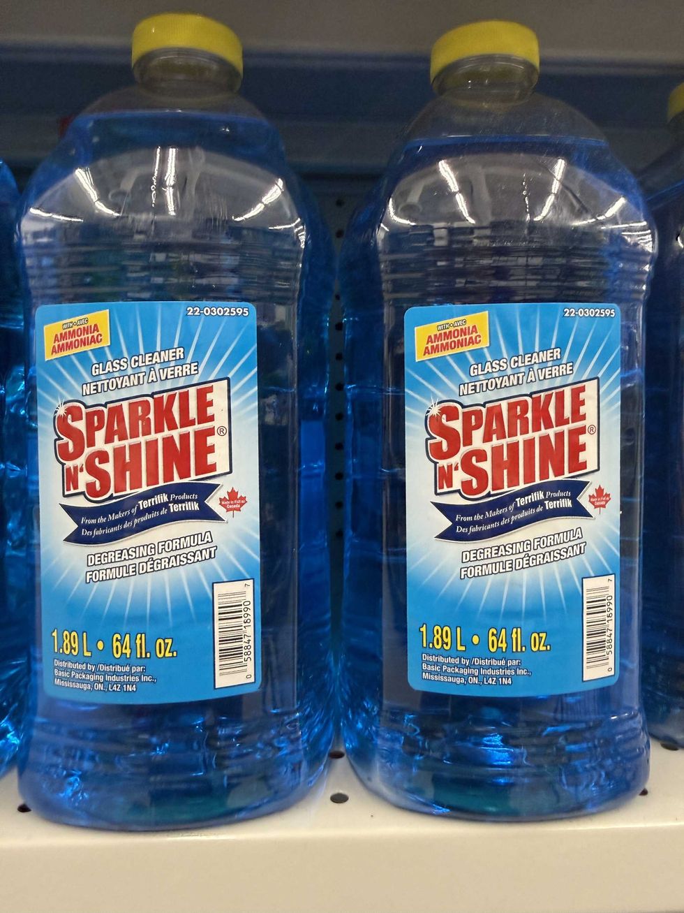 Two bottles filled with blue liquid that say Sparkle N' Shine glass cleaner.