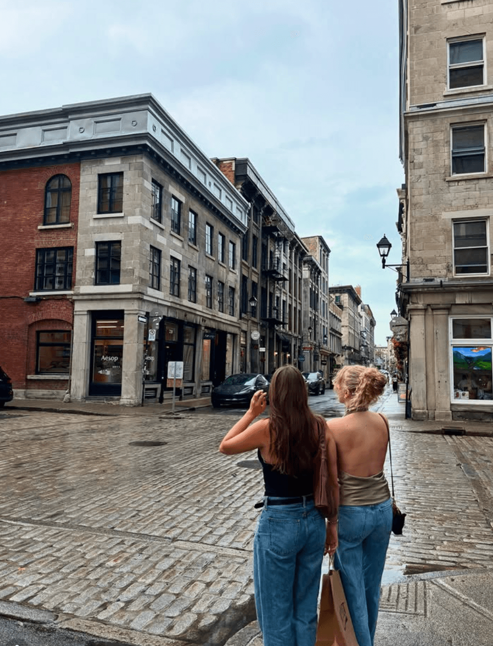 Two girls stand in a rainy Montreal.