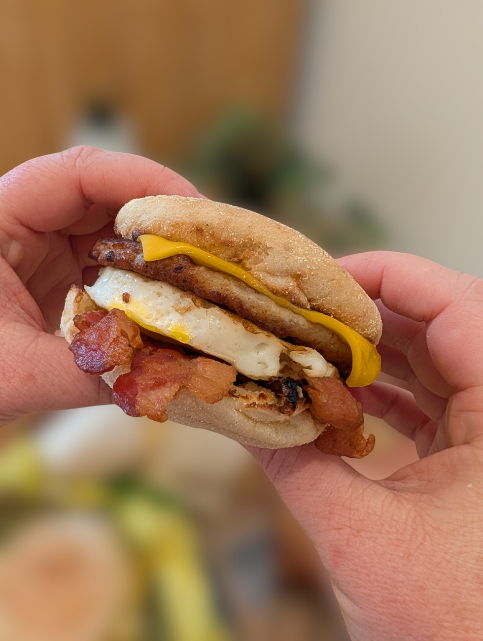 Two hands holding a McDonalds's Mighty McMuffin.
