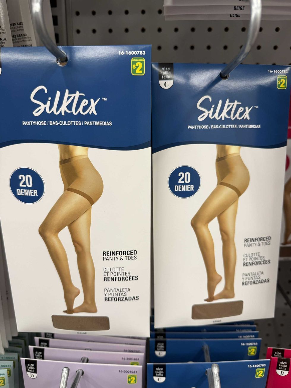 Two packs of pantyhose on a store shelf.