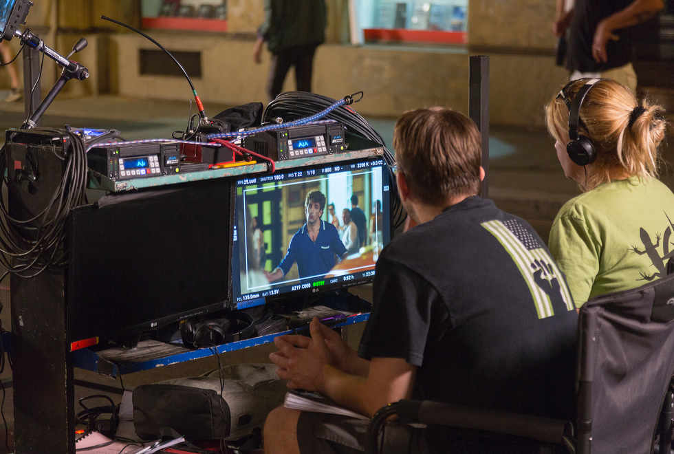 Two people behind a camera on a film set.