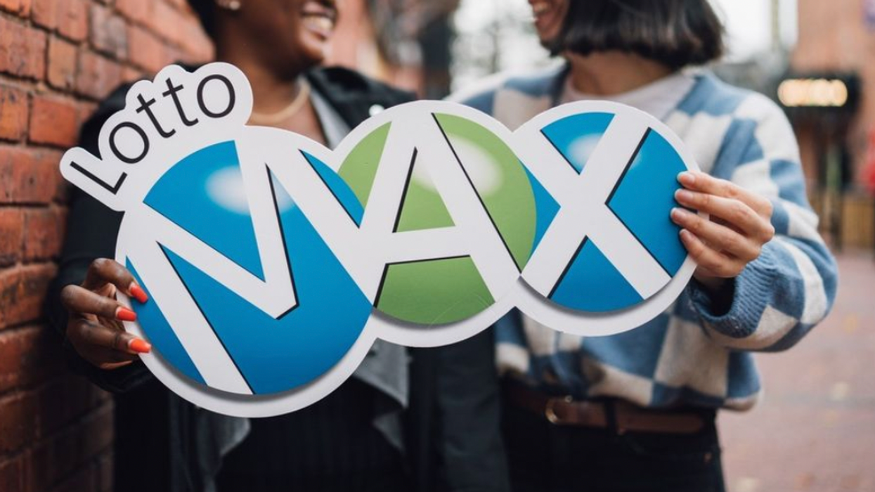 Two people holding a Lotto Max sign.