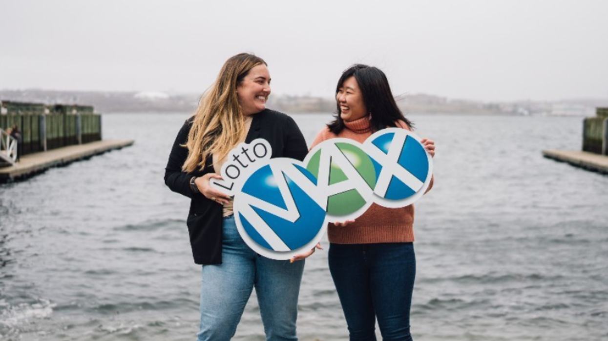 Two people holding a Lotto Max sign.