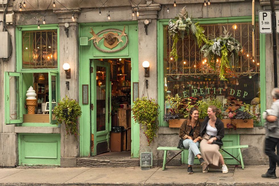 two people sitting in front of a cafe