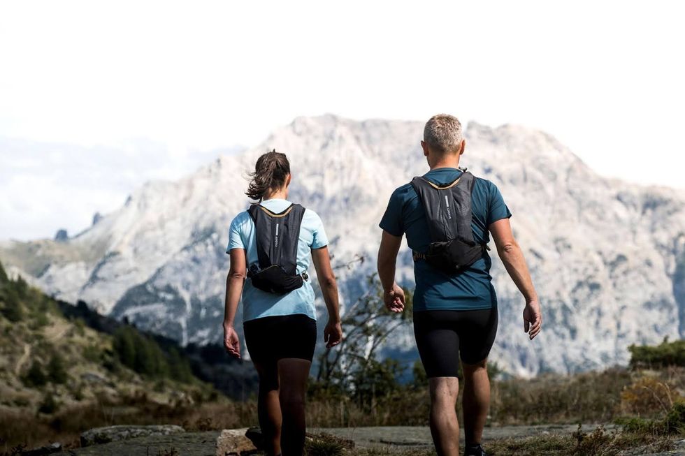 Two people walking wearing Decathlon trail running bags.