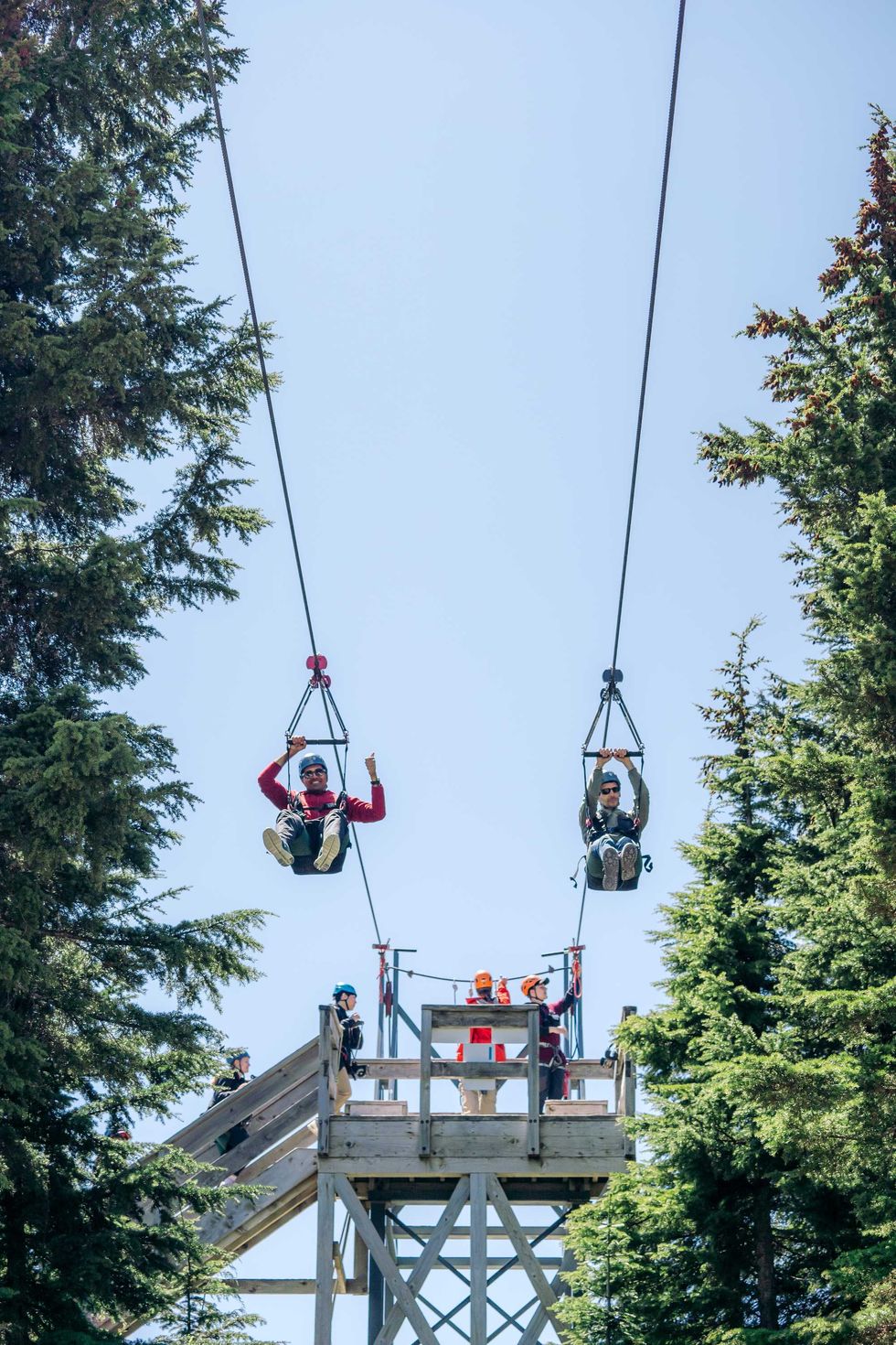 Two people ziplining at the top of Grouse Mountain.