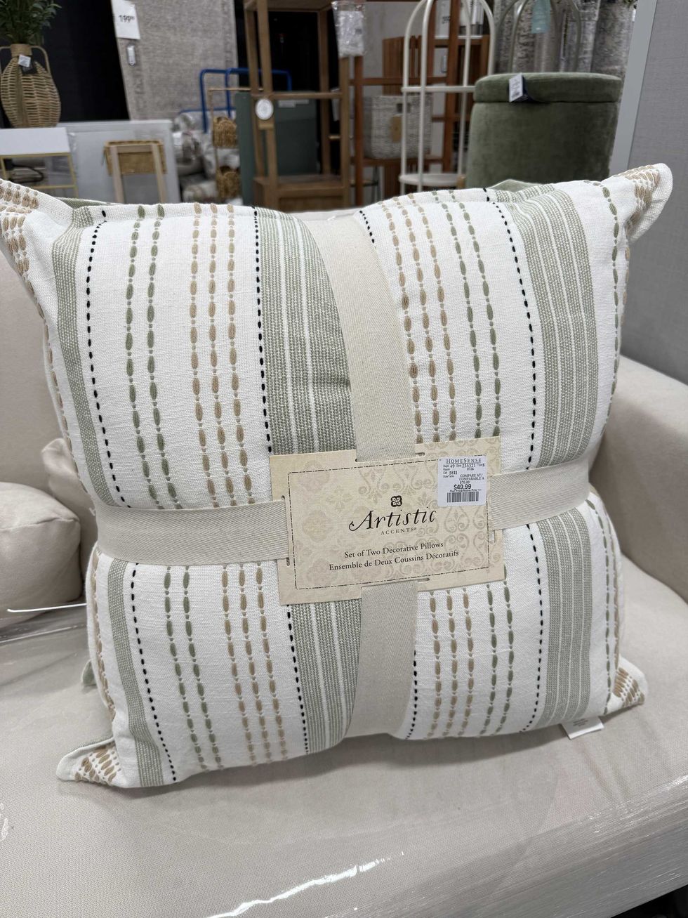 Two pillows tied together with beige and green designs on them.