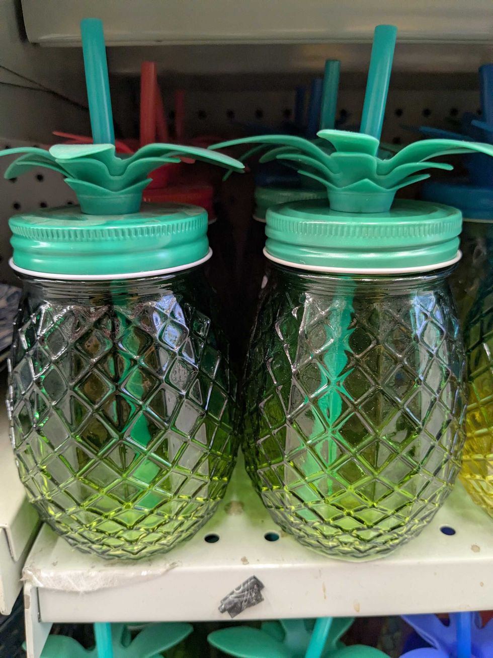 Two pineapple-shaped glasses on a shelf