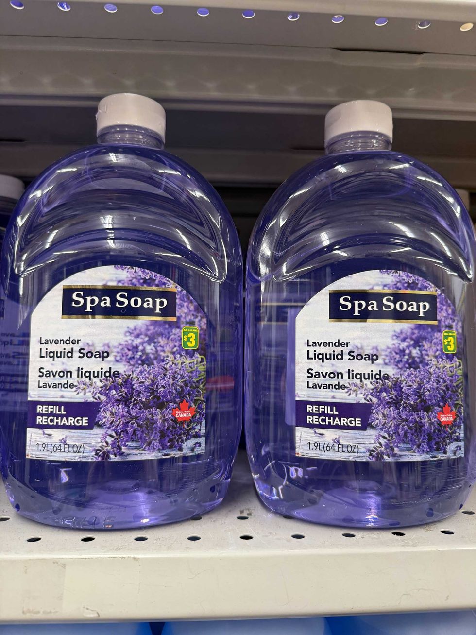 Two plastic jugs filled with purple liquid soap.