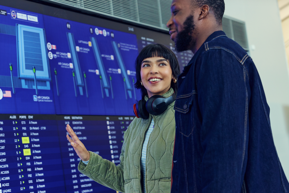 Two travellers at the information kiosk at Toronto Pearson.
