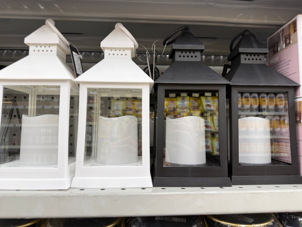 Two white lanterns next to two black lanterns with fake candles inside each one.