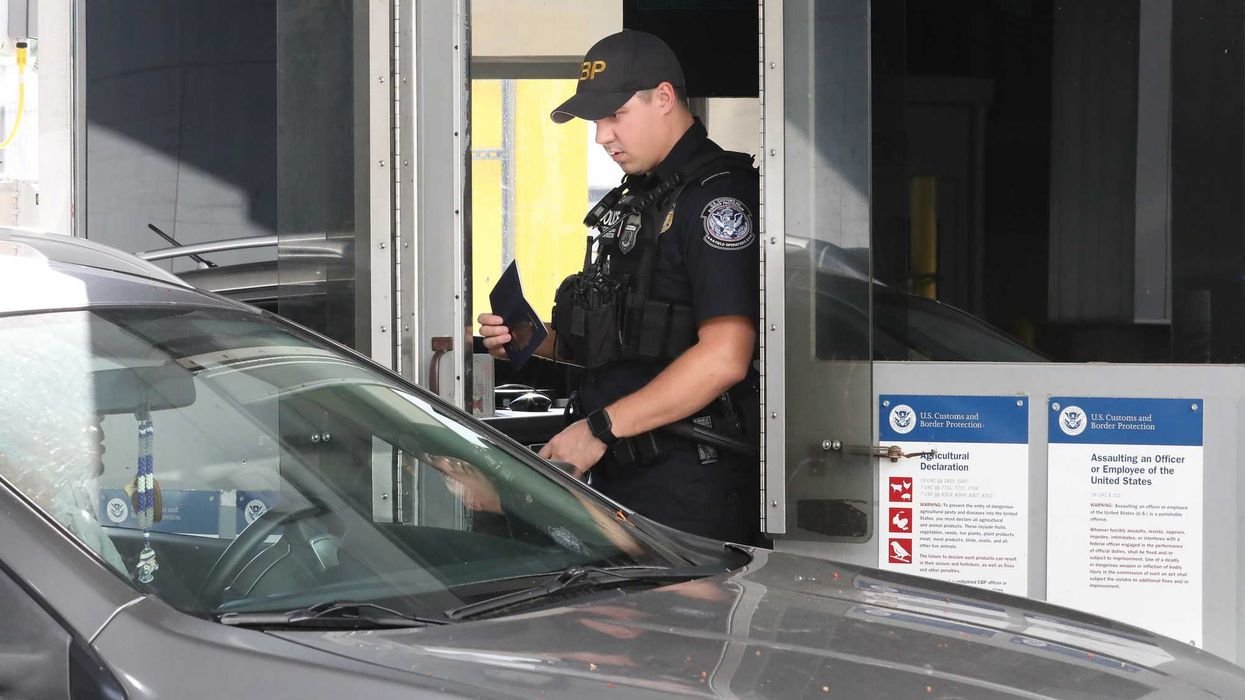 U.S. Customs and Border Patrol officer processes a driver at a land border crossing.