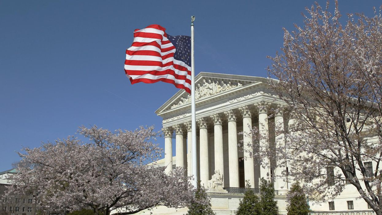 U.S. Supreme Court building with an American flag flying in front of it.