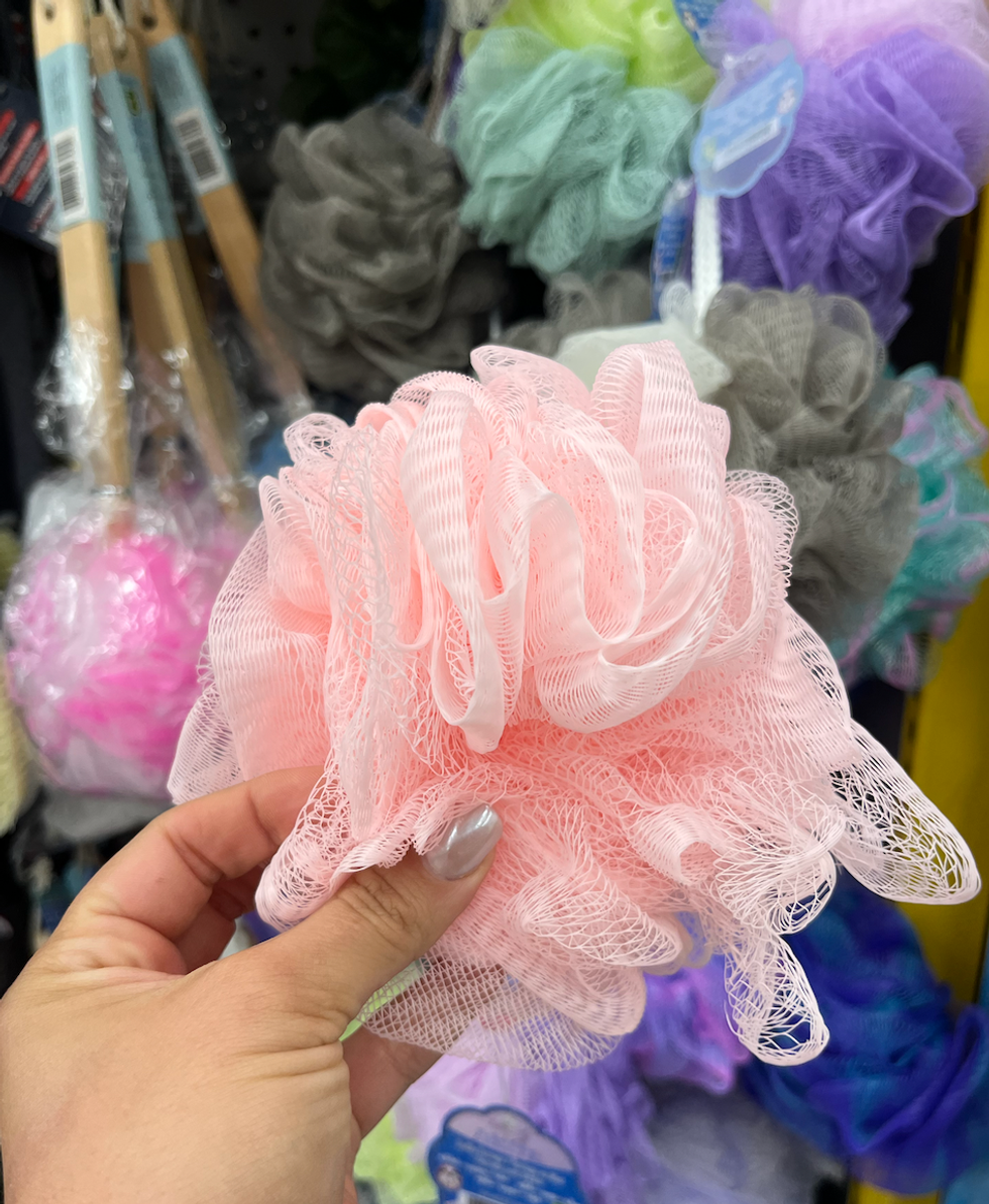 \u00c9ponge en filet rose dans une main.