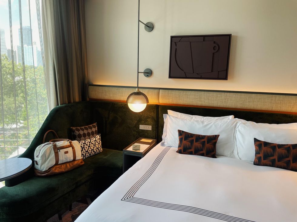 \u200bA chaise lounge and bed in a Thompson Buckhead room.