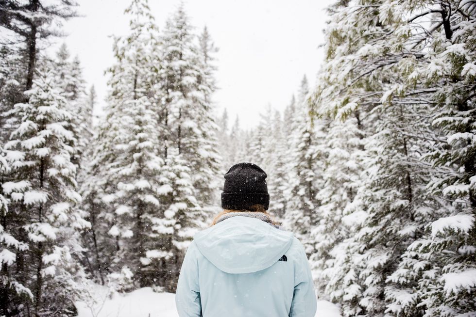 \u200bA person wearing a toque stands outside.