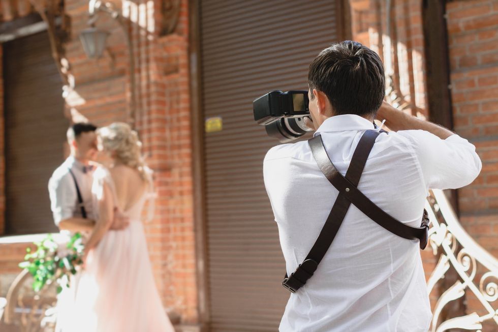 \u200bA photographer taking photos of a bride and groom on their wedding day.