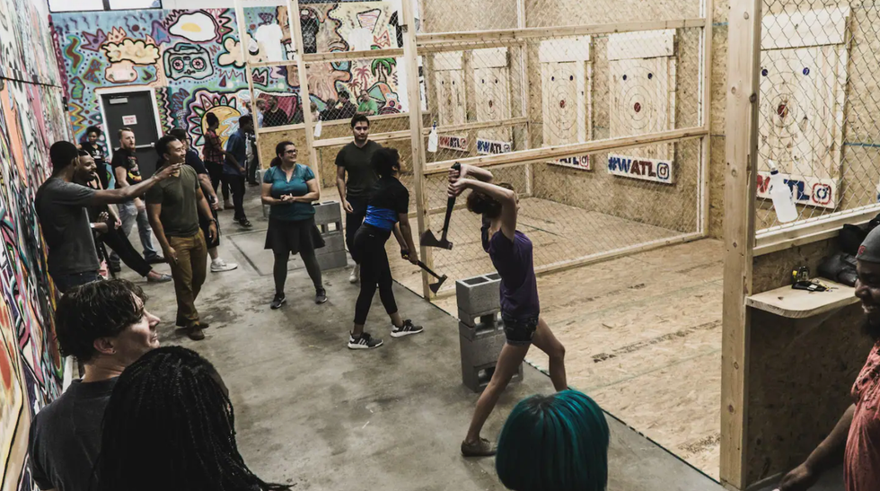 \u200bA woman throwing an axe at a target.
