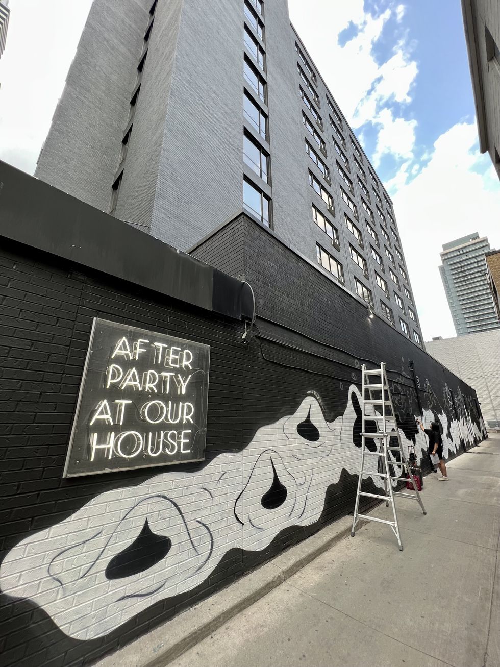 \u200bArtist Ness Lee works on a mural.