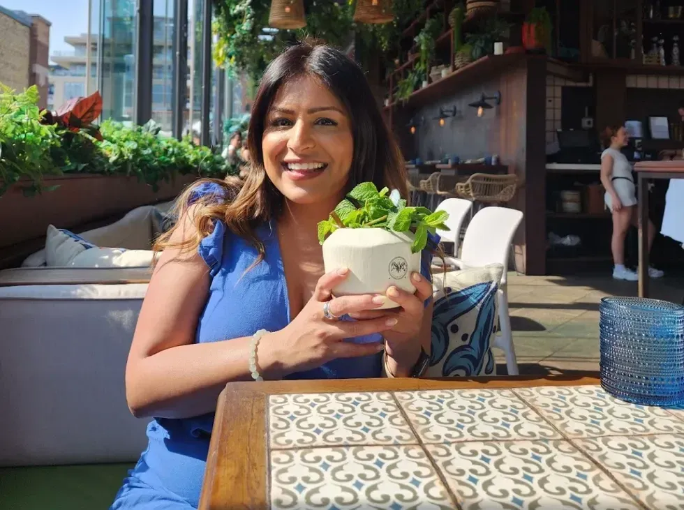 \u200bAshna drinking a mai tai on the Baro rooftop.