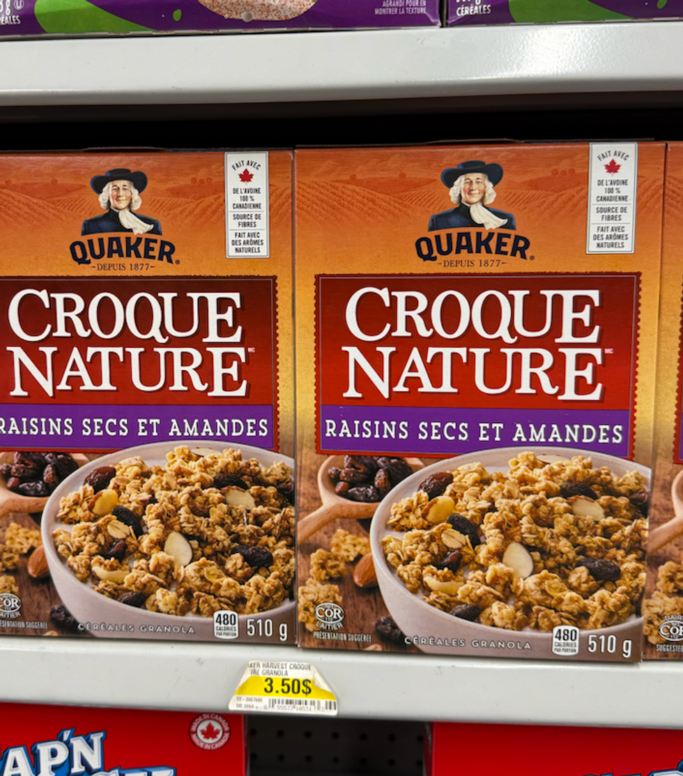 \u200bC\u00e9r\u00e9ales granola Croque Nature : Raisins secs et amandes dans leur bo\u00eete en carton sur une \u00e9tag\u00e8re du Dollarama.