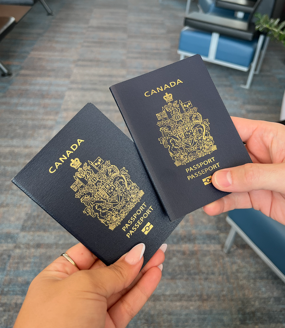 \u200bDeux passeports canadiens dans des mains \u00e0 l'a\u00e9roport.