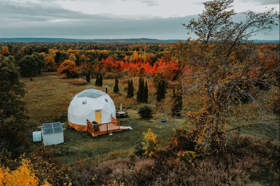 \u200bDome with a yellow door in a field.