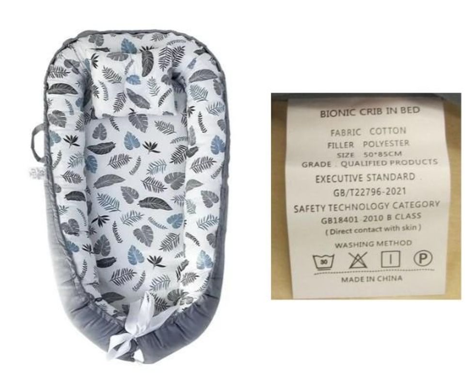 \u200bHAPDEN portable crib bed with label.