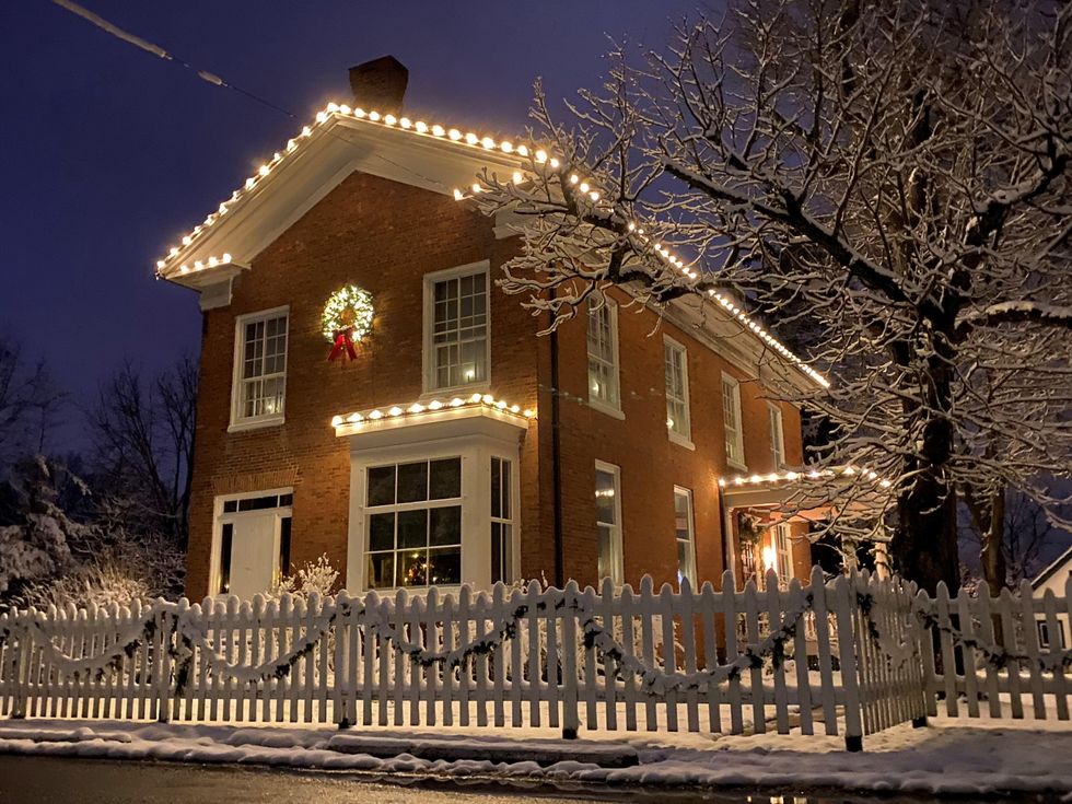 \u200bHouse covered in lights and snow.