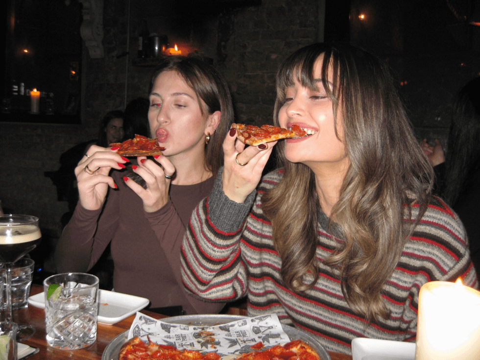 u200bPeople eating pizza.